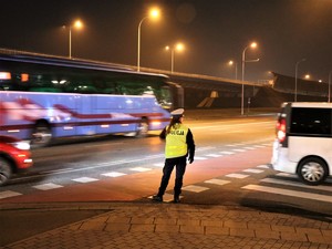 Zdjęcie ilustracyjne umundurowanej funkcjonariuszki Wydziału Ruchu Drogowego kierującej ruchem na jednej z wrocławskich ulic