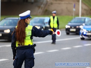 Zdjęcie kierujących ruchem funkcjonariuszy ruchu drogowego na jezdni przy stadionie miejskim we Wrocławiu.