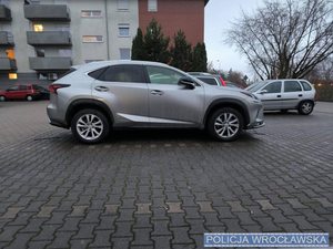 Pojazd marki Lexus na tle budynków