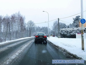 Jadące jedną z wrocławskich, zaśnieżonych ulic auta