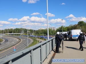 Funkcjonariusze dbający o bezpieczeństwo osób biorących udział w imprezie masowej - meczu piłki nożnej.