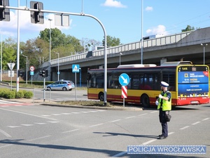 Funkcjonariusze ruchu drogowego dbający o bezpieczeństwo osób biorących udział w imprezie masowej - meczu piłki nożnej, kierujący ruchem na jednym ze skrzyżowań w okolicy stadionu miejskiego we Wrocławiu.