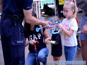 dziewczynka bierze udział w zabawach organizowanych przez policjanta.