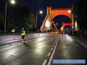 Funkcjonariuszka ruchu drogowego nadzorujący ruch na jednym z  wrocławskich skrzyżowań w trakcie zabezpieczenia 10 edycji Nocnego Półmaratonu we Wrocławiu.