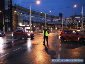 Funkcjonariusz ruchu drogowego nadzorujący ruch na jednym z  wrocławskich skrzyżowań w trakcie zabezpieczenia 10 edycji Nocnego Półmaratonu we Wrocławiu.