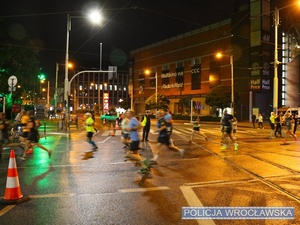 Funkcjonariusz ruchu drogowego nadzorujący ruch na jednym z  wrocławskich skrzyżowań w trakcie zabezpieczenia 10 edycji Nocnego Półmaratonu we Wrocławiu.