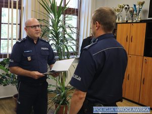 Komendant wręczający nagrodę policjantowi