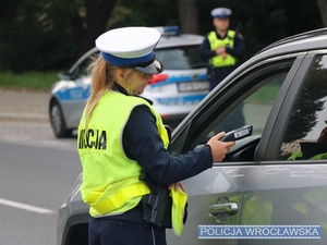 Policjantka ruchu drogowego przeprowadza badanie na zawartość alkoholu