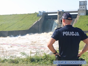 Policjant obserwujący zaporę wody w Mietkowie