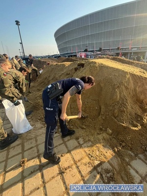 Policjantka ładująca worek z piaskiem