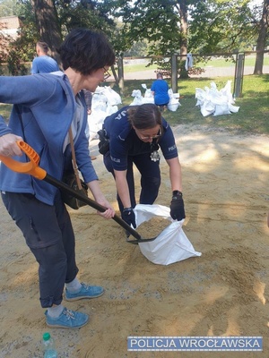 policjantka ładująca worek z piaskiem