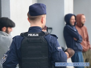 Policjant stojący przy mieszkańcach budynku