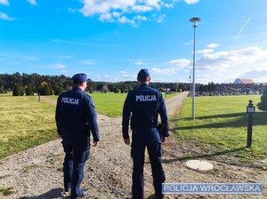 Umundurowani policjanci w trakcie patrolu terenu jednego z wrocławskich cmentarzy.