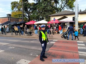 Umundurowana policjantka ruchu drogowego w trakcie kierowania ruchem przy jednym z wrocławskich cmentarzy.