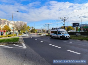 Umundurowany policjant ruchu drogowego w trakcie kierowania ruchem przy jednym z wrocławskich cmentarzy.