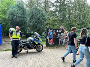 na zdjęciu widać funkcjonariusza ruchu drogowego stojącego obok motocyklu