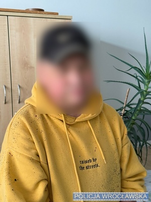na zdjeciu widać mężczyznę stojącego ubranego w żółtą bluzę