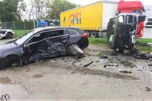 Na zdjęciu uszkodzone pojazdy podczas zdarzenia drogowego marki Opel i Porsche. Pojazd marki porsche leży na prawym boku