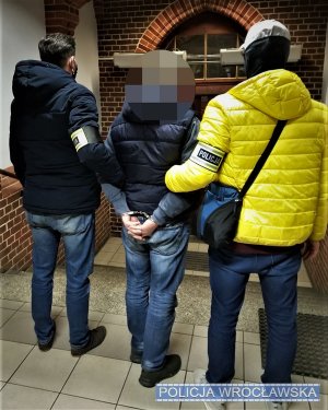 Zdjęcie przedstawia policjantów oraz zatrzymanego mężczyznę