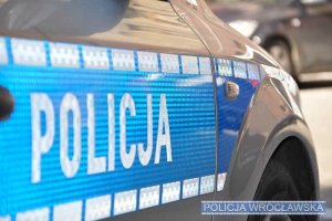 Napis POLICJA na drzwiach radiowozu