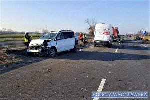 Na zdjęciu policjanci pracujący na miejscu zdarzenia drogowego oraz uszkodzone pojazdy