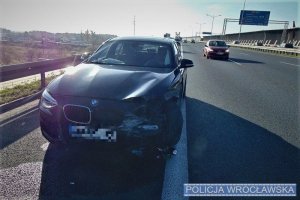Uszkodzony pojazd marki BMW stojący na pasie awaryjnym