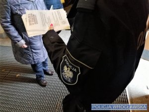 Policjantka rozdająca profilaktyczne ulotki