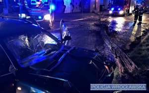 Zdjęcie przedstawiają uszkodzony pojazd, radiowóz oraz policjantów podejmujących interwencję