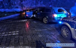 Zdjęcie przedstawiają uszkodzony pojazd, radiowóz oraz policjantów podejmujących interwencję