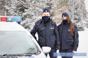 Zdjęcie przedstawia policjantów przy radiowozie