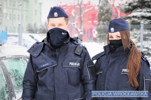 Zdjęcie przedstawia policjantów przy radiowozie