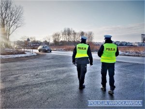 Zdjęcia przedstawiają policjantów kontrolujących pojazdy. Widoczni są funkcjonariusze w granatowych mundurach i żółtych odblaskowych, kamizelkach.