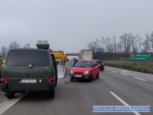 Bus koloru szarego oraz czerwony samochód osobowy uszkodzone w wyniku kolizji