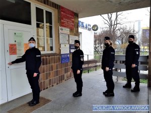 Policjanci oczekujący przed przychodnią na szczepienie