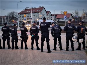 Zdjęcia przedstawiają policjantów biorących udział w zabezpieczeniu oraz policyjne radiowozy