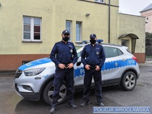 Policjanci na tle radiowozu