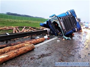 Przewrócony na bok pojazd ciężarowy przewożący drewno
