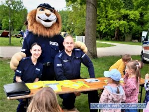 Zdjęcia przedstawiają umundurowanych policjantów na terenie parku. Obok nich znajduje się radiowóz.