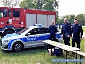 Zdjęcia przedstawiają umundurowanych policjantów na terenie parku. Obok nich znajduje się radiowóz.