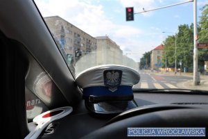 Czapka policjanta ruchu drogowego i tarcza do zatrzymywania pojazdów na podszybiu radiowozu