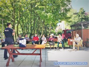 Zdjęcia przedstawiają policjanta prowadzącego prelekcje dla seniorów