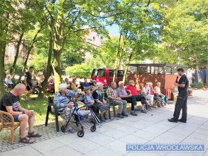 Zdjęcia przedstawiają policjanta prowadzącego prelekcje dla seniorów