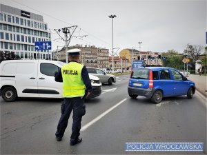 Zdjęcia przedstawiają miejsce zdarzenia oraz policjantów wydziału ruchu drogowego w żółtych kamizelkach, którzy kierują ruchem