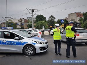 Zdjęcia przedstawiają miejsce zdarzenia oraz policjantów wydziału ruchu drogowego w żółtych kamizelkach, którzy kierują ruchem