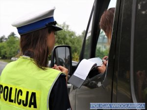 Policjantka podająca kierowcy mandat do podpisu