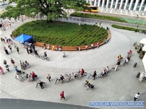 Rowerzyści oczekujący na oznakowanie roweru przez policjantów