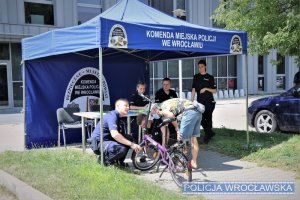 Zdjęcia przedstawiają umundurowanych policjantów znakujących rowery